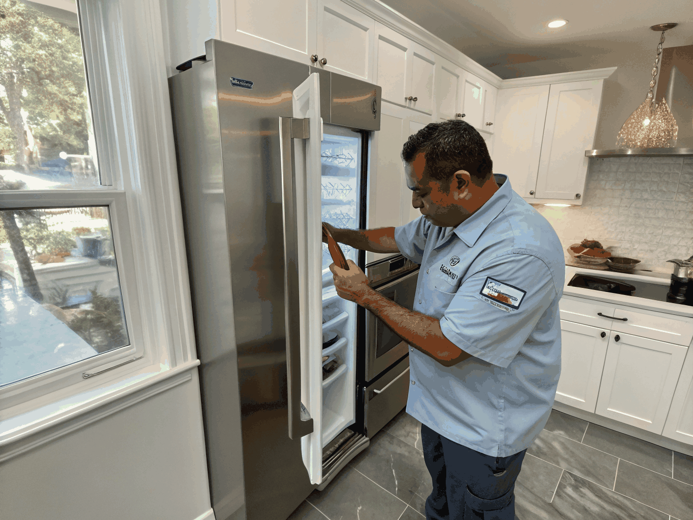 Technician inspecting a modern stainless steel refrigerator